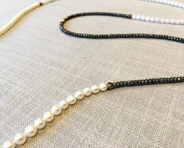 closeup of gemstone bead necklace comprising white pearl, white moonstone and pyrite.