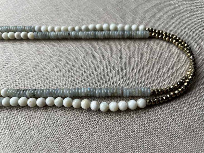 side view of gemstone bead necklace comprising white moonstone, grey moonstone and golden pyrite