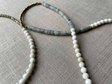 closeup of gemstone bead necklace comprising white moonstone, grey moonstone and golden pyrite