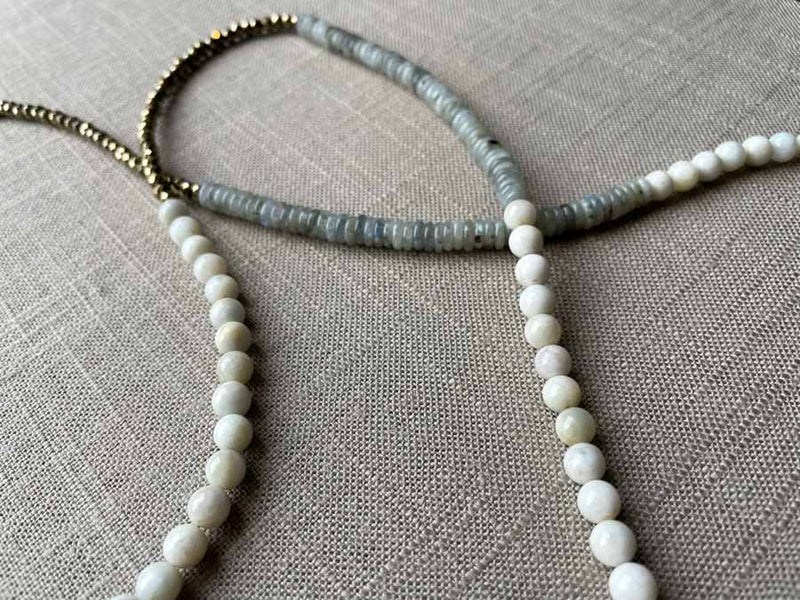 closeup of gemstone bead necklace comprising white moonstone, grey moonstone and golden pyrite