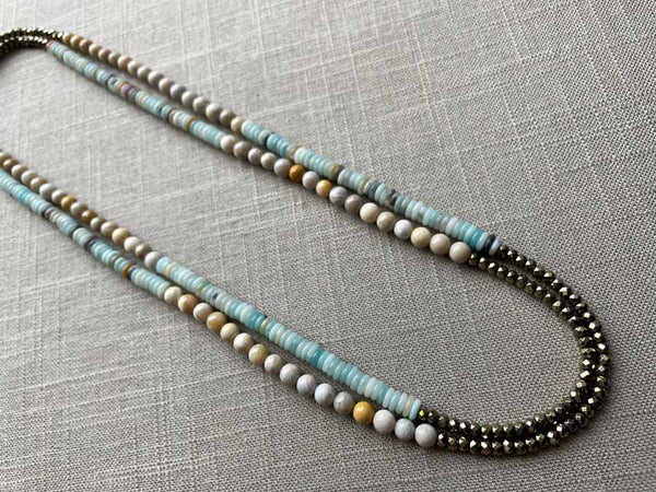 top view of gemstone bead necklace comprising blue chrysoprase, beige fossil jasper and golden pyrite