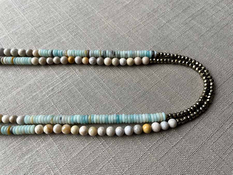 side view of gemstone bead necklace comprising blue chrysoprase, beige fossil jasper and golden pyrite