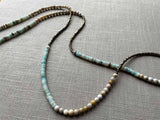 closeup of gemstone bead necklace comprising blue chrysoprase, beige fossil jasper and golden pyrite