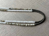 side view of gemstone bead necklace comprising white moonstone, off-white moonstone and dark grey pyrite