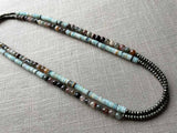 top view of gemstone bead necklace comprising blue chrysoprase, neutral strawberry quartz and dark grey pyrite