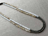 top view of gemstone bead necklace comprising white moonstone, neutral rutilated quartz and dark grey pyrite