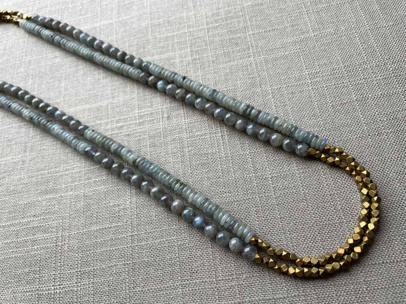 top view of gemstone bead necklace comprising grey moonstone, blue labradorite and bronze