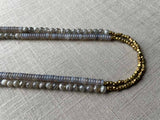 side view of gemstone bead necklace comprising grey moonstone, purple smoky quartz and bronze