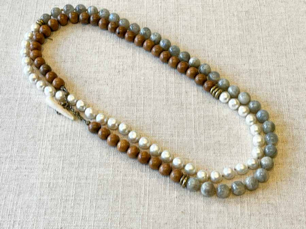 top view of gemstone bead necklace comprising white pearl, moonstone and exotic wood