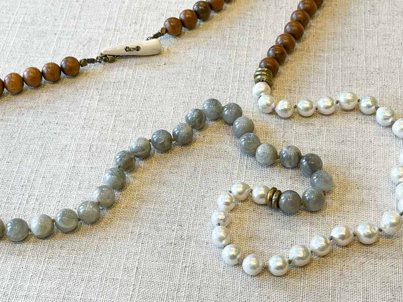 closeup of gemstone bead necklace comprising white pearl, moonstone and exotic wood