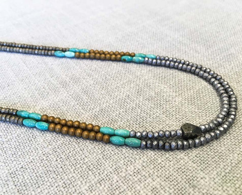 side view of gemstone bead necklace comprising turquoise, matte gold and matte silver