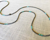 closeup of gemstone bead necklace comprising turquoise, gold hematite and silver hematite