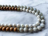 side view of gemstone bead necklace comprising white pearl, grey moonstone and exotic wood with antler clasp