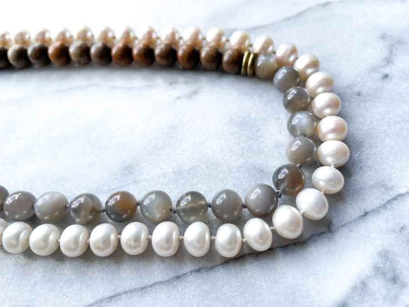 side view of gemstone bead necklace comprising white pearl, grey mink moonstone and exotic wood with antler clasp