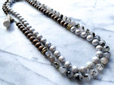 top view of gemstone bead necklace comprising grey pearl, tourmalated quartz and exotic wood with antler clasp