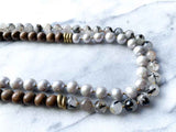 side view of gemstone bead necklace comprising grey pearl, tourmalated quartz and exotic wood with antler clasp