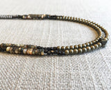 side view of gemstone bead necklace comprising tan tahitian shell, dark bronze and matte light gold and matte silver