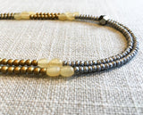 side view of gemstone bead necklace comprising light yellow horn, matte gold and matte silver