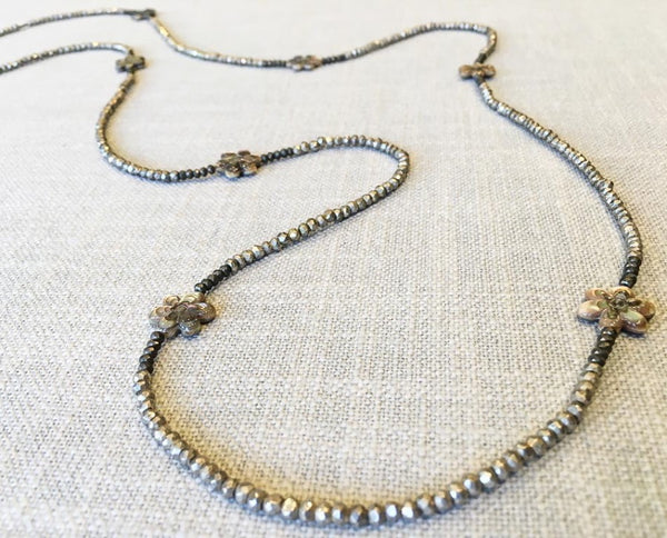 closeup of gemstone bead necklace comprising carved golden shell, silver-plate pyrite and raw pyrite