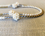 side view of gemstone bead necklace comprising hand sewn white pearl balls, matte gold and matte silver