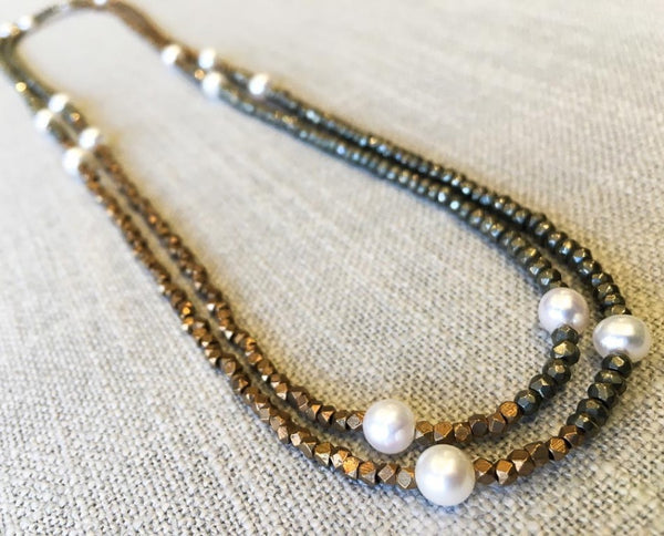 top view of gemstone bead necklace comprising white pearl, bronze and dark grey pyrite