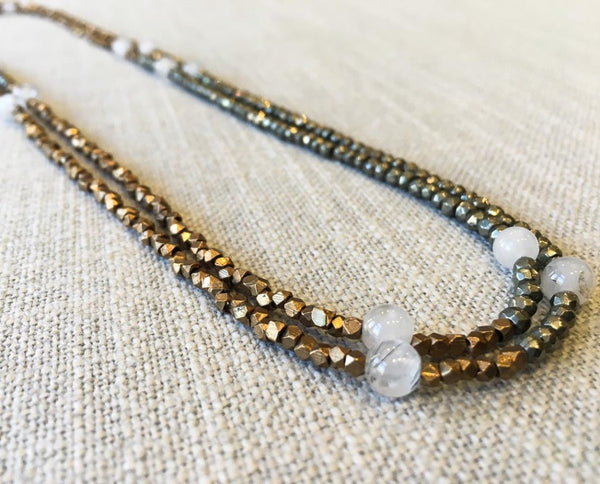 top view of gemstone bead necklace comprising white moonstone, bronze and dark grey pyrite