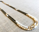 top view of gemstone bead necklace comprising cream pearl, beige shell and light gold hematite