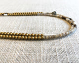 side view  of gemstone bead necklace comprising neutral shell and matte gold