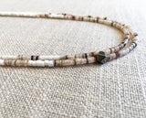 side view  of gemstone bead necklace comprising white shell 