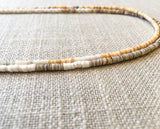 closeup of gemstone bead necklace comprising white shell