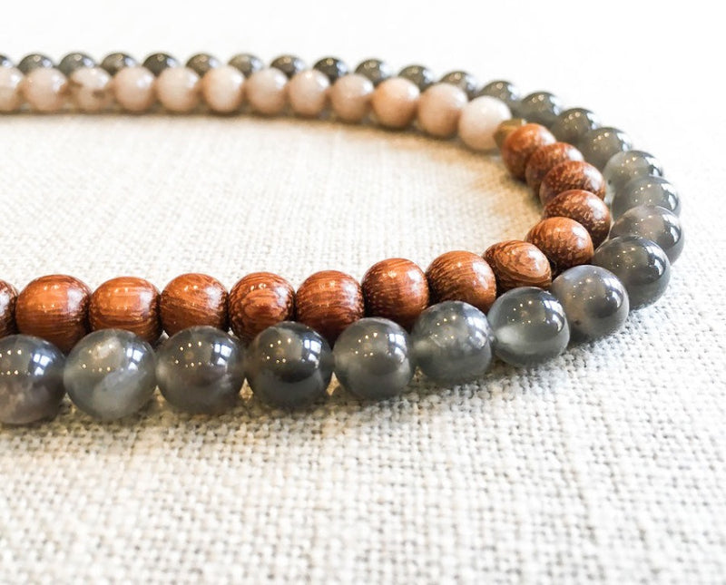 side view  of gemstone bead necklace comprising grey moonstone, taupe quartz and exotic wood