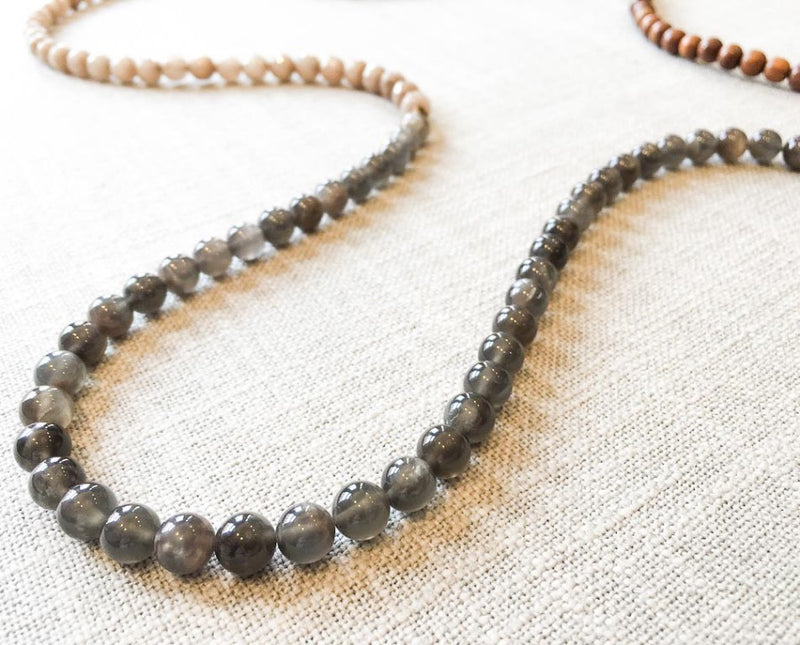 closeup of gemstone bead necklace comprising grey moonstone, taupe quartz and exotic wood