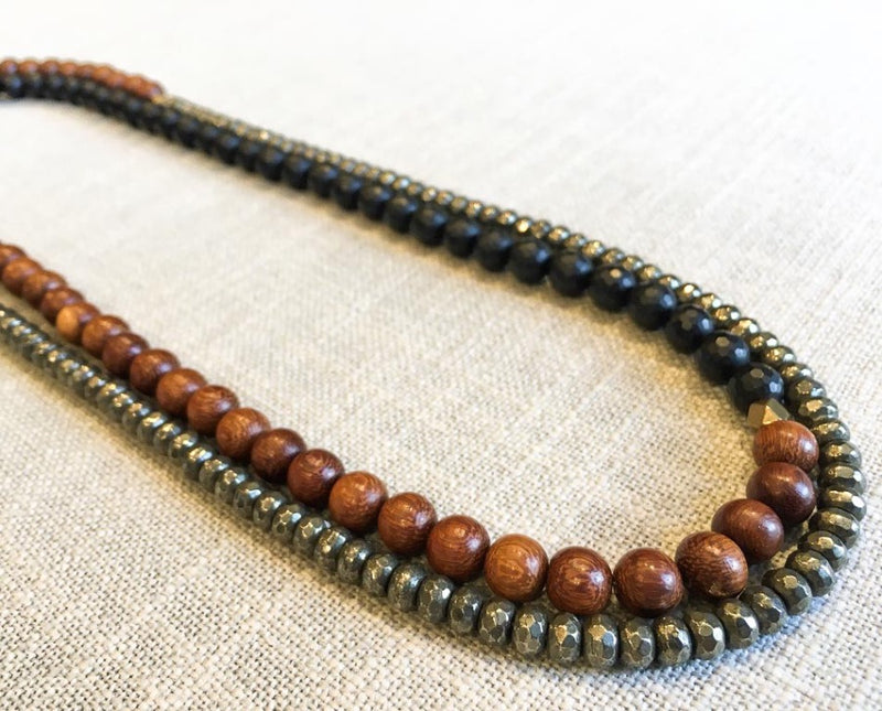 top view of gemstone bead necklace comprising black onyx, dark grey pyrite and exotic wood