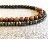 side view  of gemstone bead necklace comprising black onyx, dark grey pyrite and exotic wood