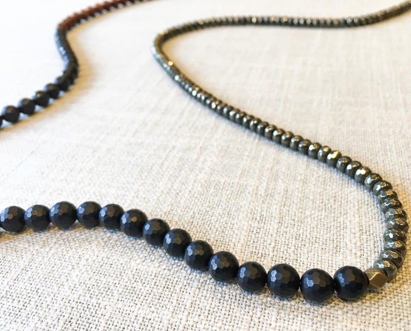 closeup of gemstone bead necklace comprising black onyx, dark grey pyrite and exotic wood