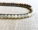 side view of gemstone bead necklace comprising white moonstone, dark grey pyrite and exotic wood