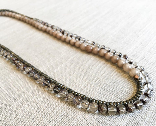 top view of gemstone bead necklace comprising neutral shadow quartz, dark grey pyrite and taupe quartz