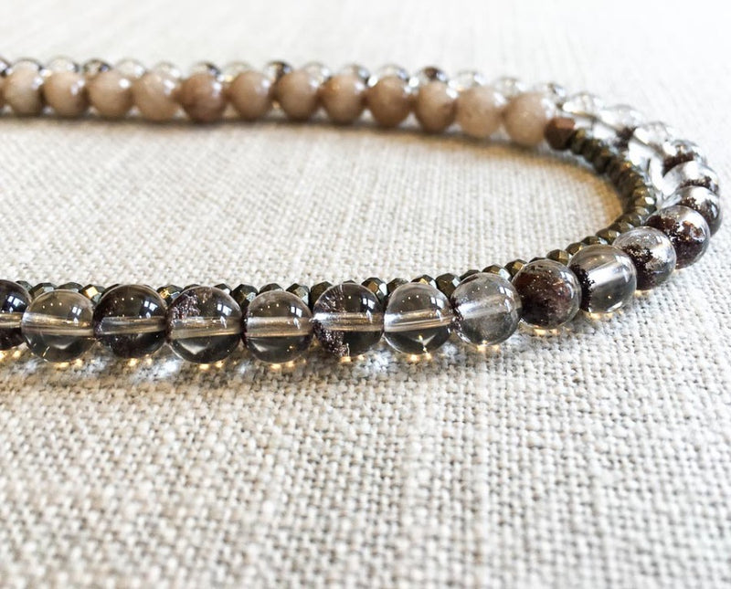 side view  of gemstone bead necklace comprising neutral shadow quartz, dark grey pyrite and taupe quartz