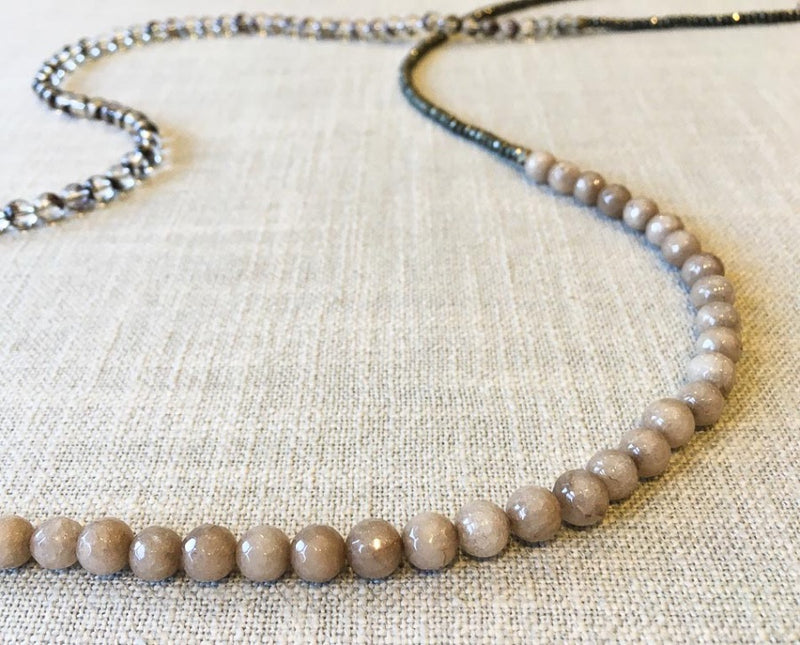 closeup of gemstone bead necklace comprising neutral shadow quartz, dark grey pyrite and taupe quartz