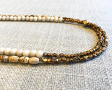 side view  of gemstone bead necklace comprising tan landscape jasper, off-white fossil jasper and bronze