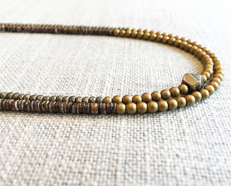 side view  of gemstone bead necklace comprising brown shell, matte light gold and matte gold