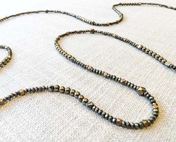 closeup of gemstone bead necklace comprising dark grey pyrite and bronze