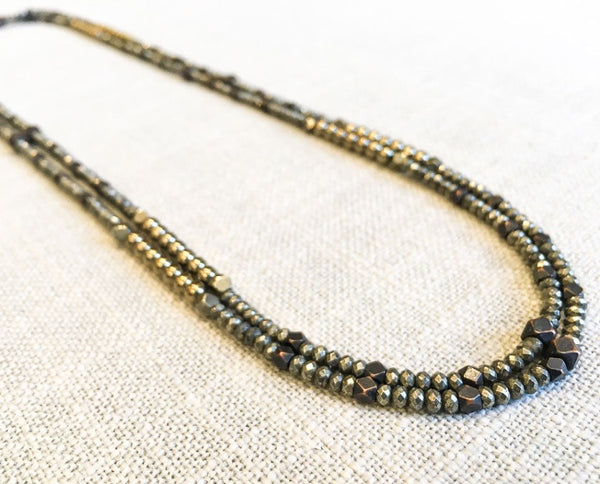 top view of gemstone bead necklace comprising dark bronze, dark grey pyrite and bronze