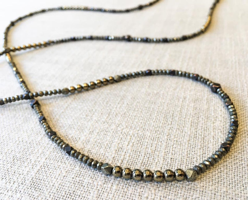 closeup of gemstone bead necklace comprising dark bronze, dark grey pyrite and bronze