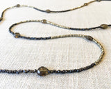 closeup of gemstone bead necklace comprising dark bronze, golden pyrite and smoky quartz