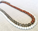 top view of gemstone bead necklace comprising grey moonstone, white moonstone and exotic wood