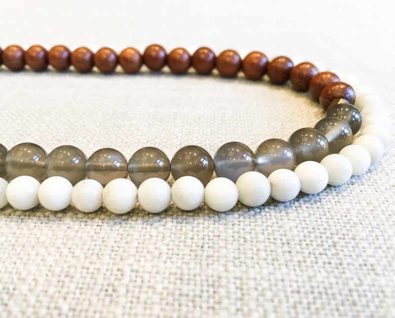 side view of gemstone bead necklace comprising grey moonstone, white moonstone and exotic wood