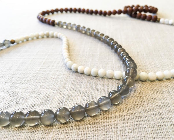 closeup of gemstone bead necklace comprising grey moonstone, white moonstone and exotic wood