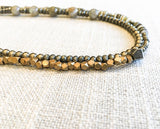 side view  of gemstone bead necklace comprising green labradorite, neutral shell and metallics