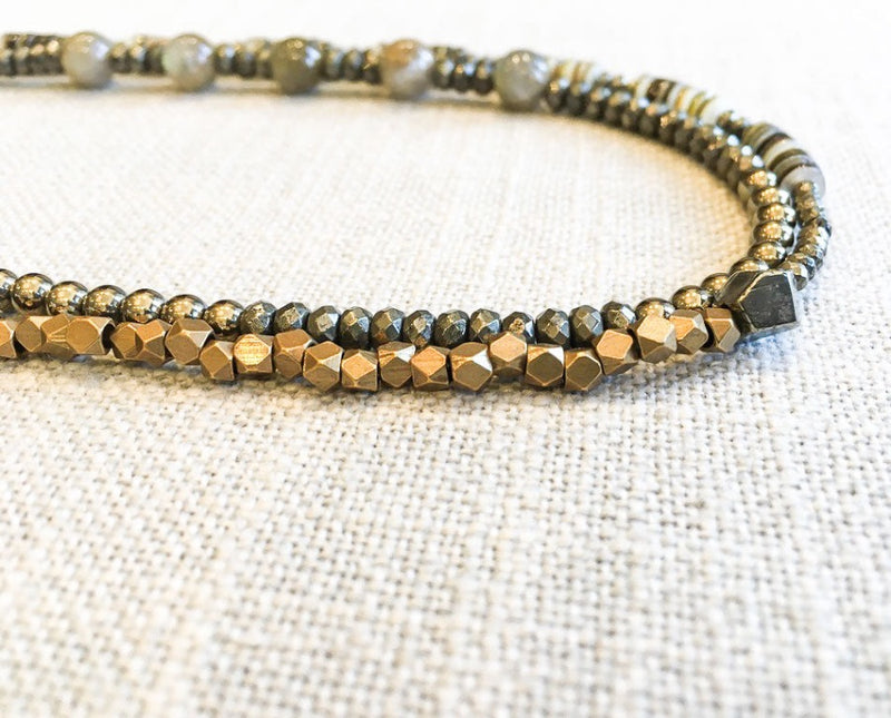 side view  of gemstone bead necklace comprising green labradorite, neutral shell and metallics